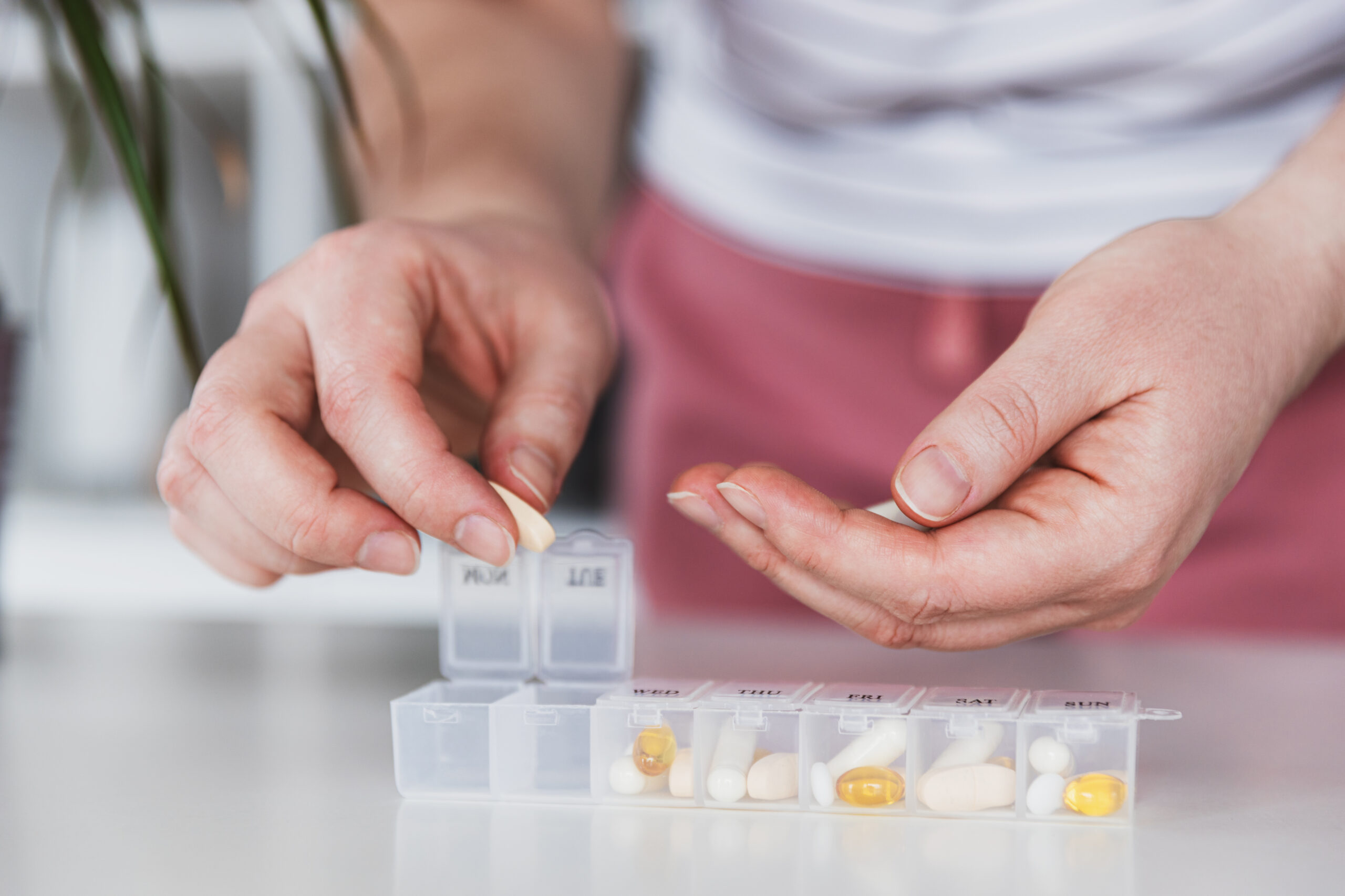 Someone is dispensing tablets into a tablet tray